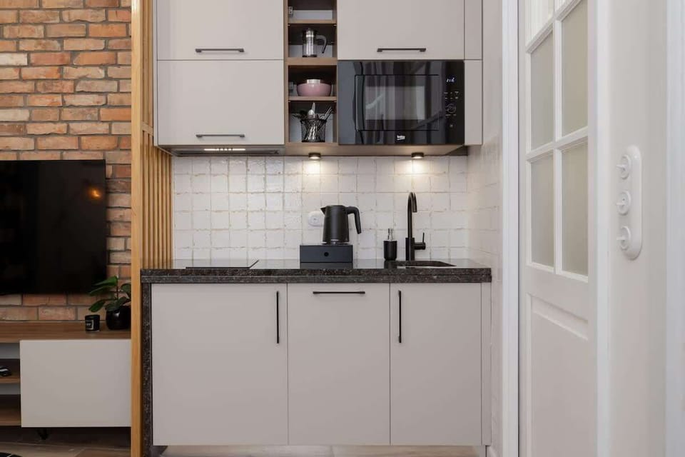 A compact kitchen with upper and lower cabinetry, a stove.
