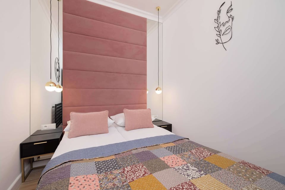 A close-up of the bed with a quilted cover and a art work positioned above the headboard.
