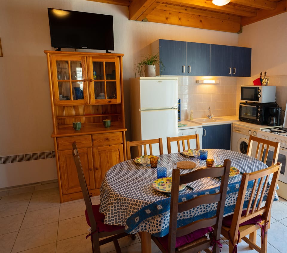 Fully equipped kitchen with dining table, TV, armchair and air conditioning