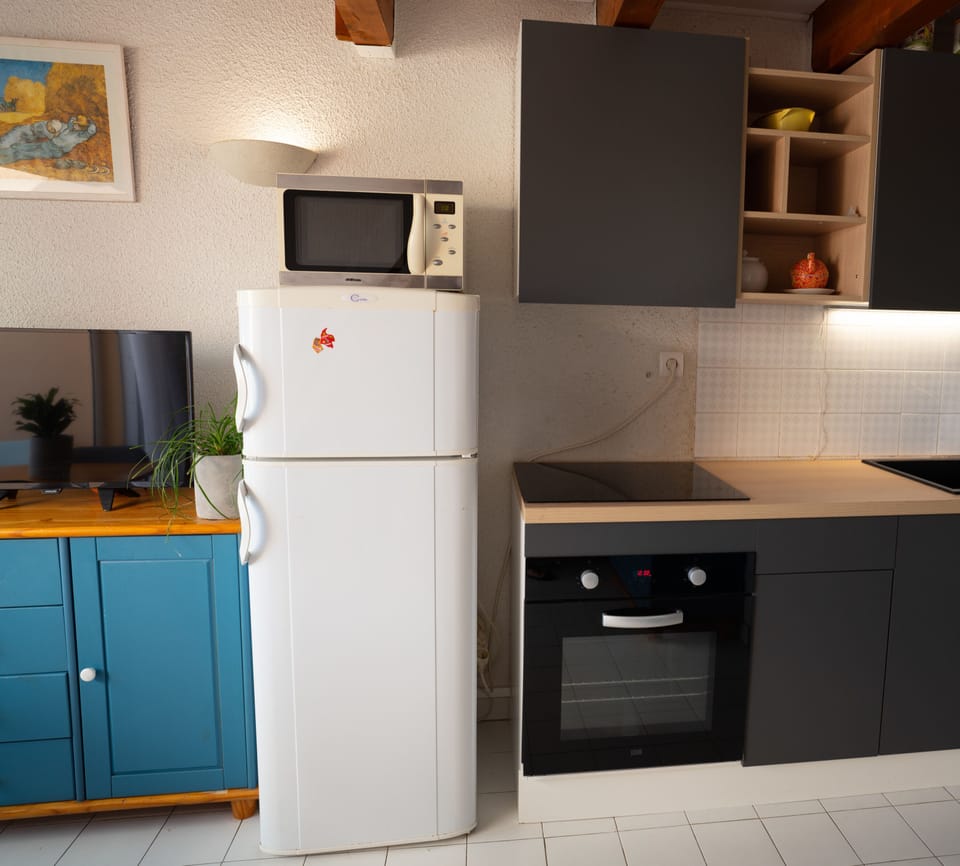 Kitchen with oven, toaster, coffee machine, fridge and freezer.