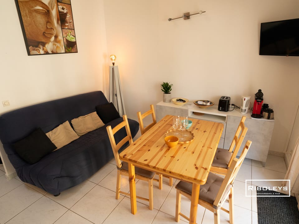 Air-conditioned living room with kitchen, sofa and dining area