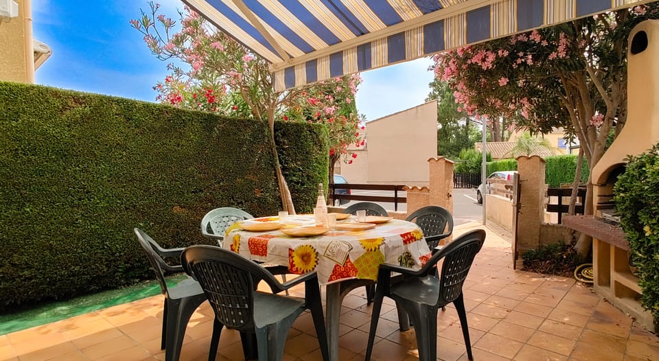 Terrace with awning, barbecue and garden furniture
