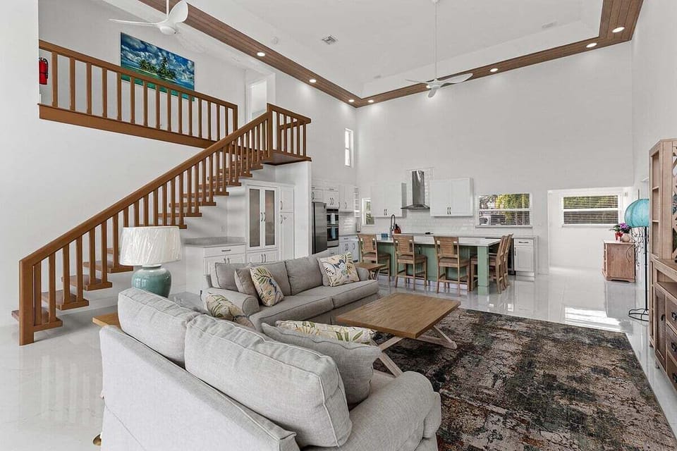 Soaring ceilings, generous seating, waterfront windows, and an open staircase create an impressive yet comfortable gathering space.