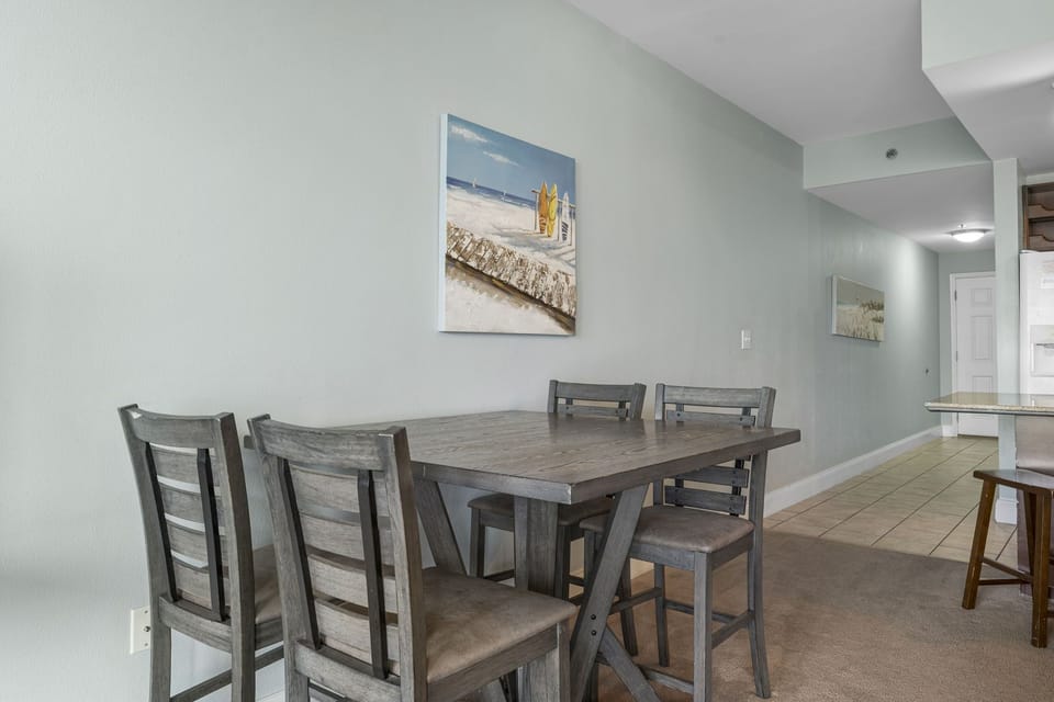 Dining area with rustic wooden table and chairs in a calm, light-filled space.