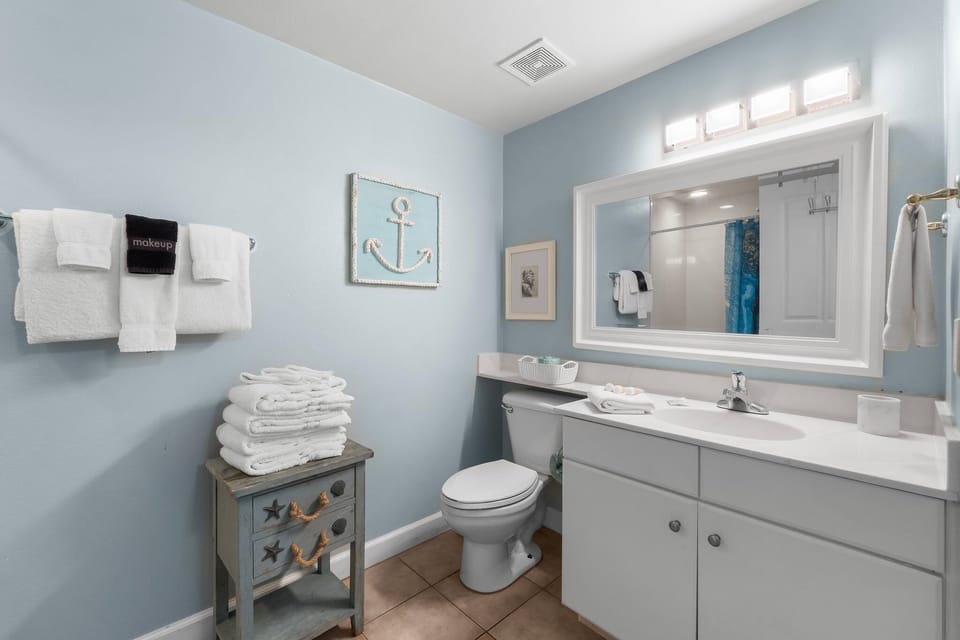 Coastal-inspired bathroom with ample towels and a large mirror for convenience.