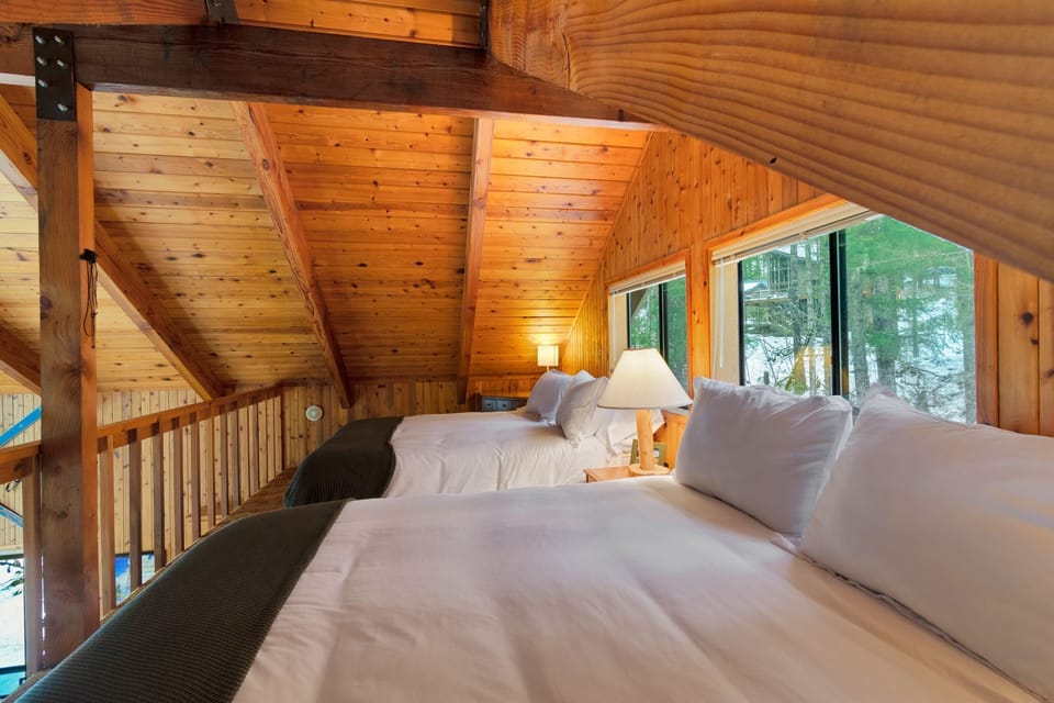 Two Queen beds with sleeping for four with plush, luxury bedding.