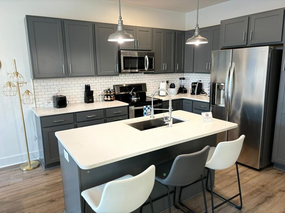 Spacious kitchen with a sleek island, stainless steel appliances, and modern lighting.