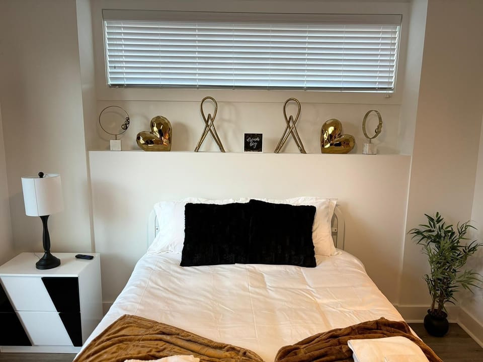 Cozy bedroom with stylish decor, gold accents, and a comfortable queen bed.