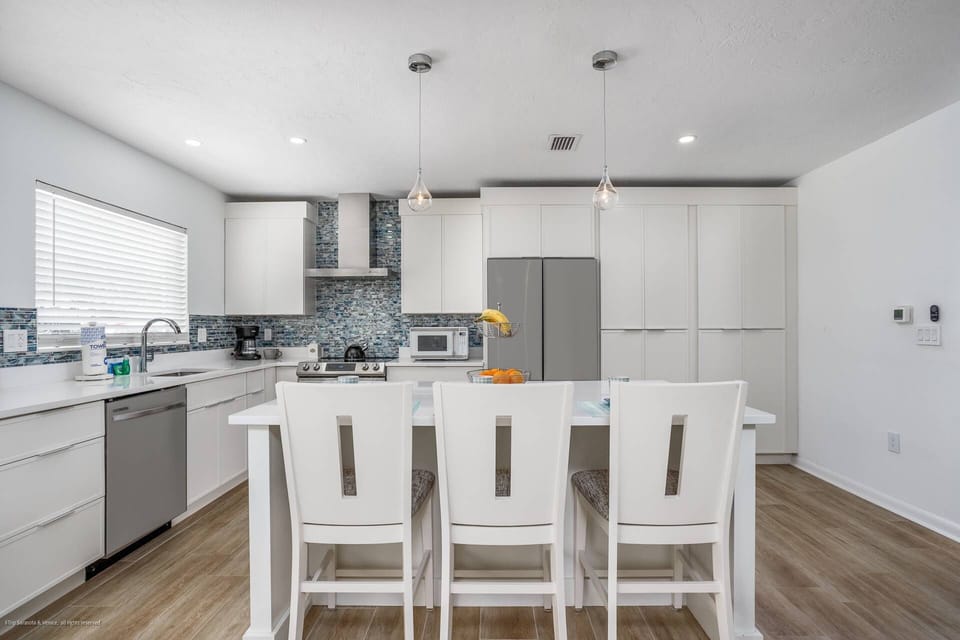 Newly renovated, modern kitchen with custom cabinet, solid stone counters and a large island,