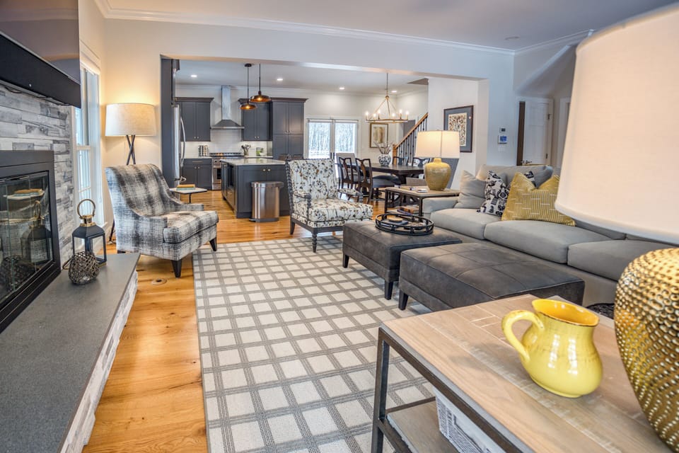 The open-plan living space features a cozy living room adorned with a gas fireplace, perfect for guests to unwind and relax.