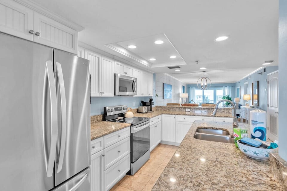 Modern kitchen w/ stainless steel appliances & generous counter space for cooking.