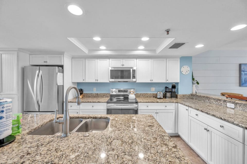 Wide kitchen view w/ ample counters, clean lines & a functional open layout.