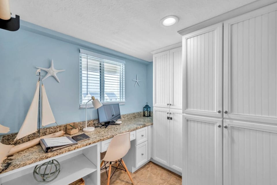 Cozy bedroom corner w/ beach-inspired decor & ample storage cabinetry.