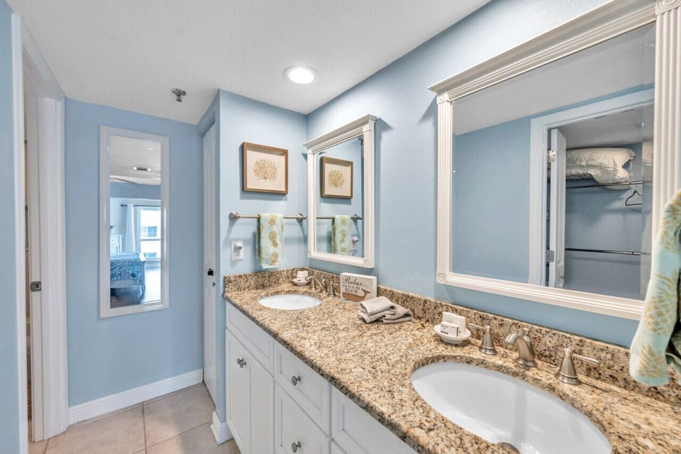 Spacious bathroom vanity w/ granite counters & bright, well-lit mirrors