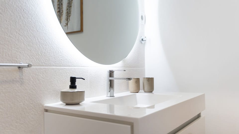 Freshen up in the contemporary bathroom, featuring a stylish backlit mirror and a sleek vanity for your comfort.
#Bathroom #ModernDesign #LovelyStay
