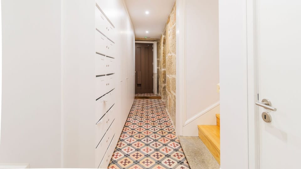 Step into this charming apartment greeted by unique patterned tiles and a blend of modern white storage and rustic stone walls, hinting at the delightful character within. The entryway promises a comfortable and stylish stay from the moment you arrive.