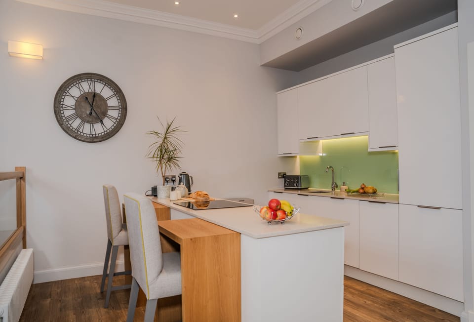 Electric oven, induction hob and a sit-up island seating two guests in the kitchen area