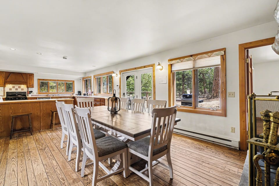 Gather around this spacious dining table where your group can share meals while enjoying forest views through large windows.