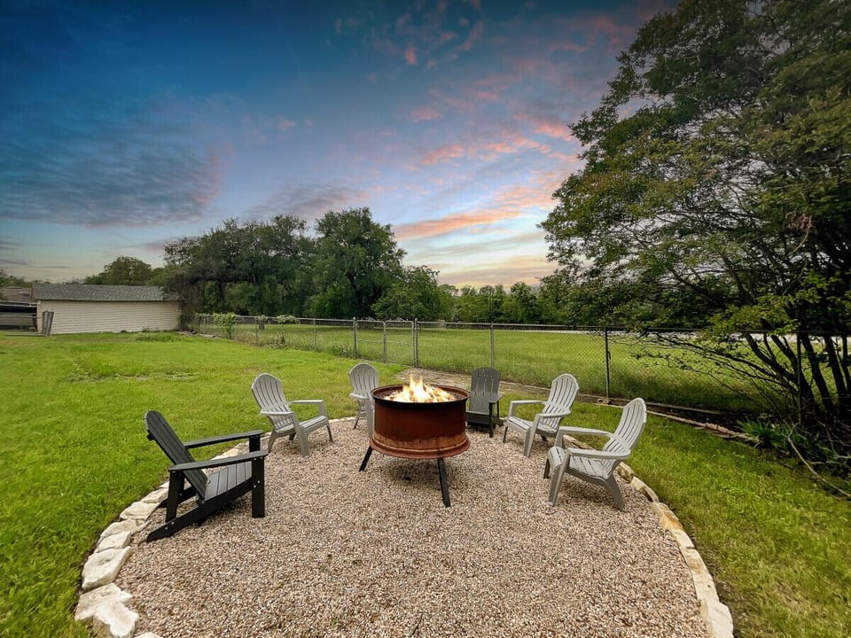 Twilight tranquility: Adirondack chairs encircle a warm fire pit, reflecting the serene beauty of the lakeside evening.