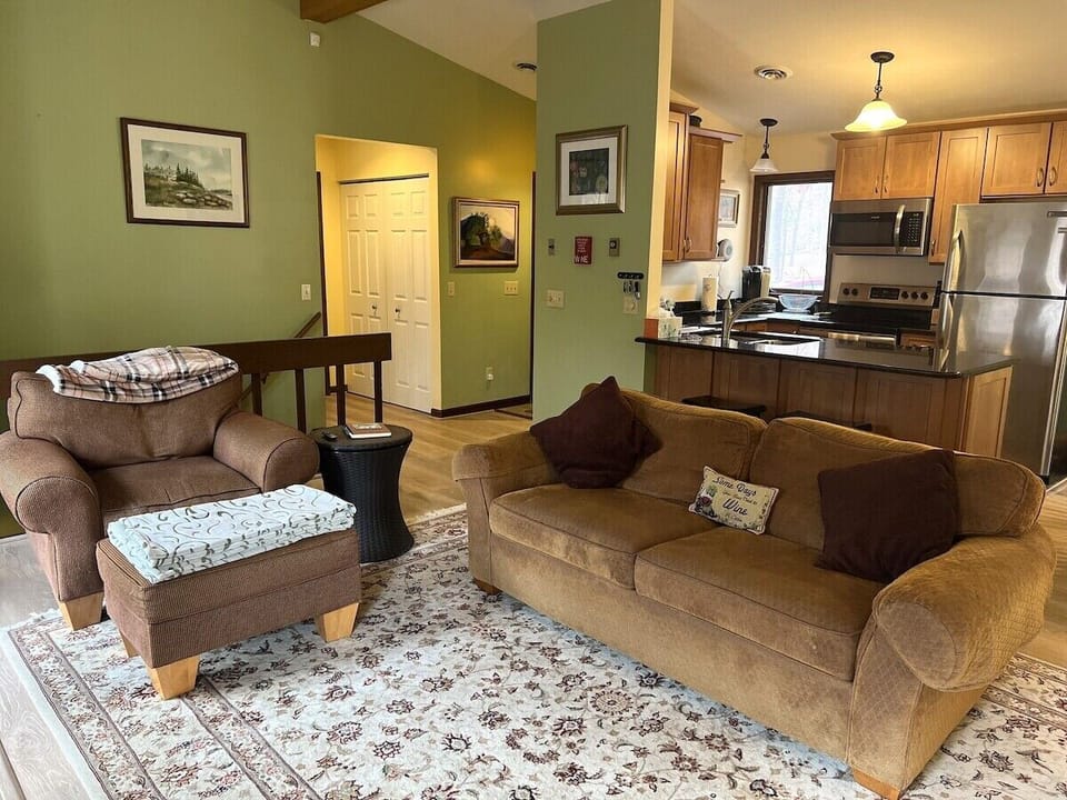 Main level living room looking into the entryway and kitchen 