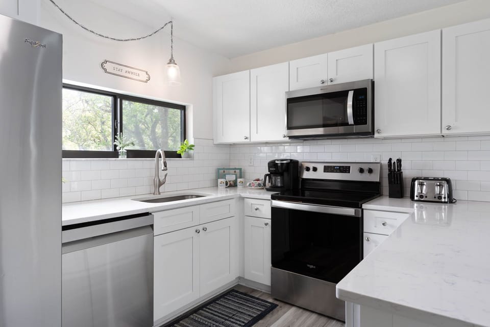In this bright, polished kitchen, mornings begin with pancakes on the stove, coffee brewing, and sunlight slipping through the window. It is where sleepy conversations turn into family plans for the beach, and simple breakfasts become part of the memory.