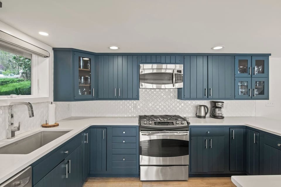 Modern kitchen with sleek stainless steel appliances and elegant blue cabinetry. Perfect for cooking and entertaining, offering a stylish and functional space for culinary adventures.