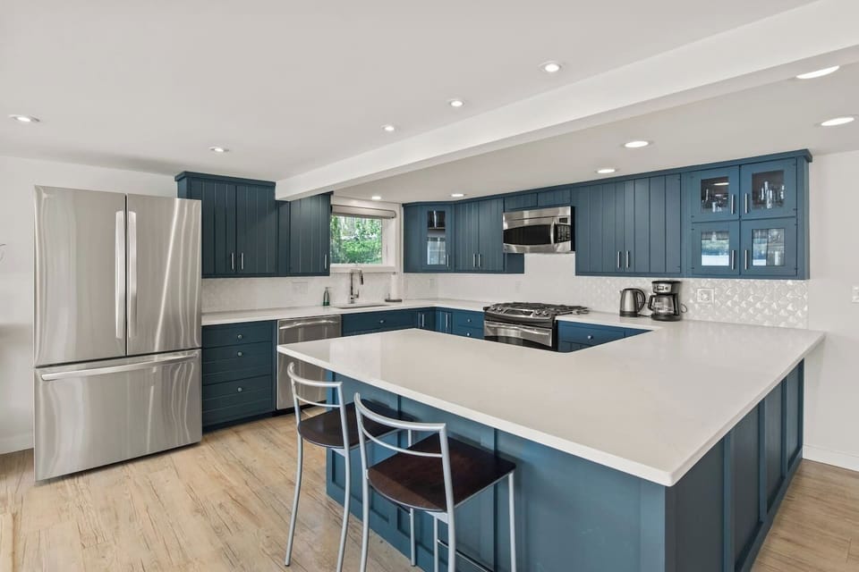 Modern kitchen with sleek stainless steel appliances and ample counter space. Perfect for cooking and entertaining, featuring a spacious island with seating. Ideal for culinary enthusiasts!