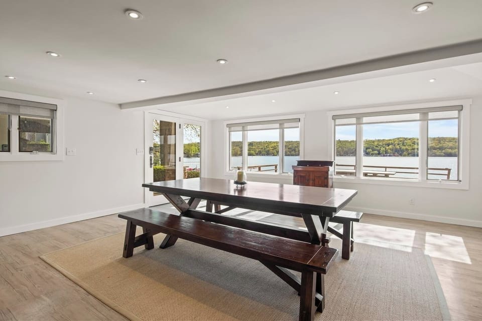 Bright and airy dining area with stunning lake views. Enjoy meals with natural light pouring in through large windows, creating a serene and picturesque setting. Perfect for family dinners and gatherings!