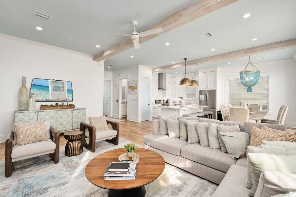 Relax in this stunning open-concept living space where warm wood beams meet coastal elegance, creating your perfect home away from home.