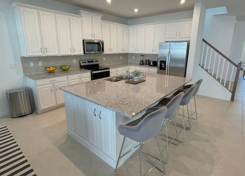 Modern kitchen with granite island and seating, perfect for entertaining and culinary adventures.