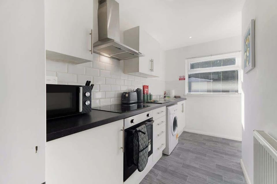 Kitchen equipped with all essentials, including a washer & dryer, oven, fridge and full cookware set.