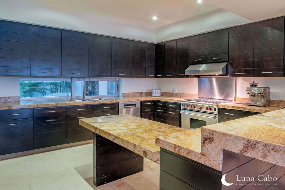 Full kitchen with granite countertops, modern appliances, and ample prep space.