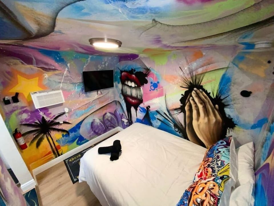 Explore Unit 2's mural-filled walls, a visual delight from every angle. Enjoy entertainment on a 32-inch smart TV and rest in comfort on a full-sized bed for two. Where art meets relaxation in Wynwood's vibrant embrace. 