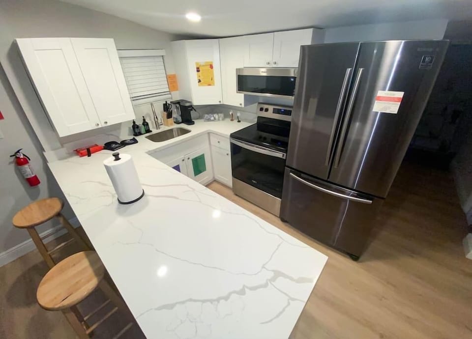Step into our modern kitchen, a culinary haven with granite countertops, fully stocked with premium kitchenware, a symphony of spices, and stainless steel appliances. Pots and pans await your creativity, while chic bar stools invite conversations. 