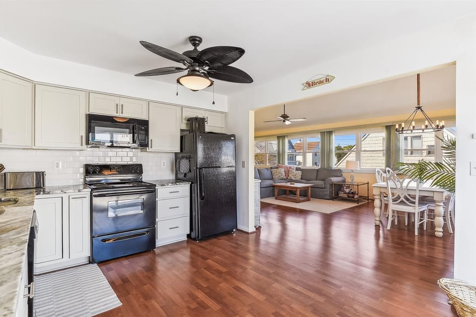 Step into your bright beachside retreat, where gleaming hardwood floors flow from the fully-equipped kitchen into your open living and dining space—perfect for gathering after sun-soaked days.