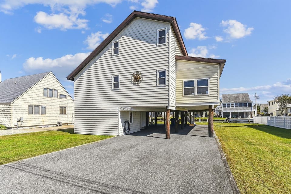 Elevated beach home featuring covered parking and a quiet residential setting near the shore, perfect for coastal getaways.