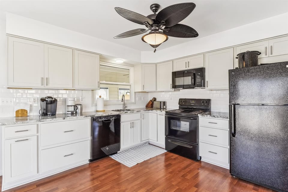 Your fully-equipped kitchen features white cabinetry, modern appliances, and warm wood floors—perfect for whipping up vacation meals together.