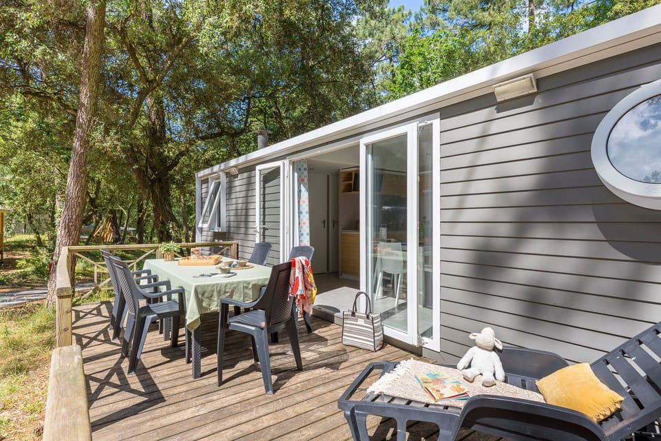 Enjoy al fresco dining on a private deck, surrounded by lush greenery for a peaceful outdoor experience.