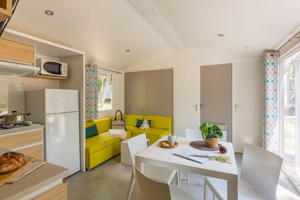 Bright, modern living space featuring a well-equipped kitchen, cozy seating area, and large windows letting in natural light.