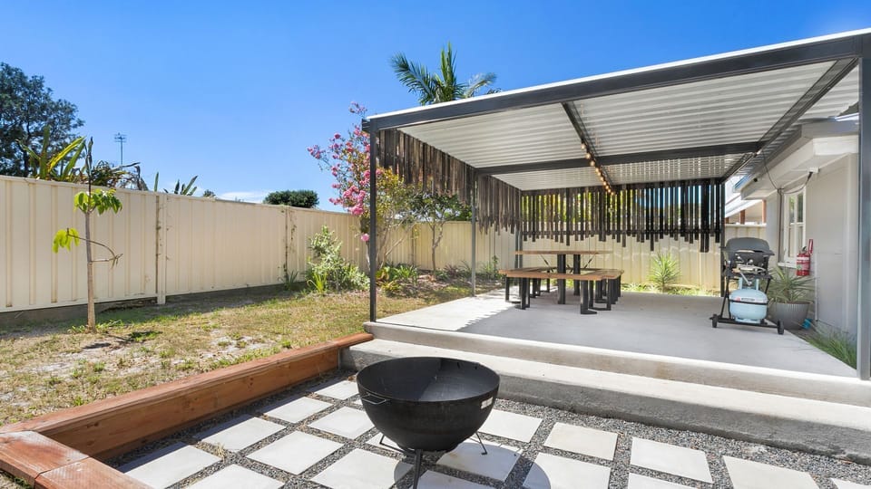 Large outdoor entertaining area with table and chairs and BBQ