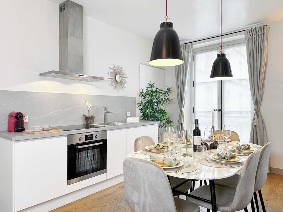 A large dining table between the kitchen and living room