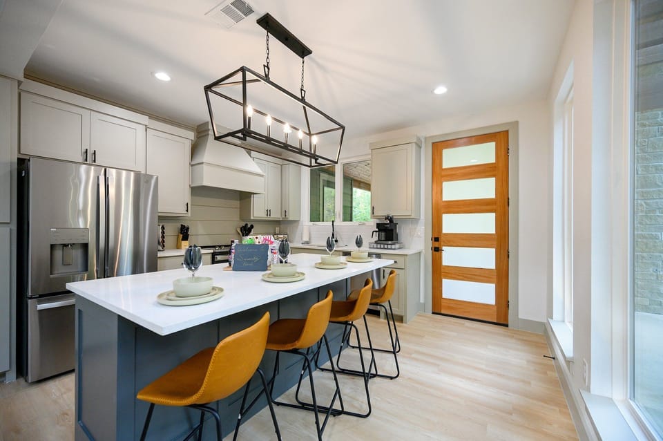 Sleek kitchen with stainless steel appliances and spacious island for cooking.