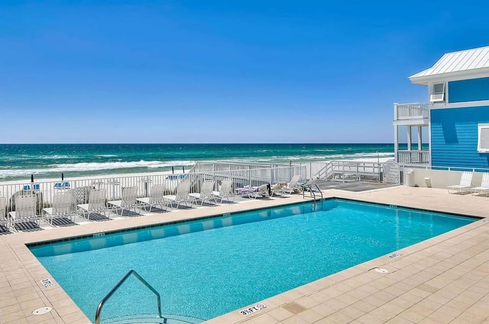 Beachfront property features a sparkling pool deck with direct ocean access and pristine white sand beach.