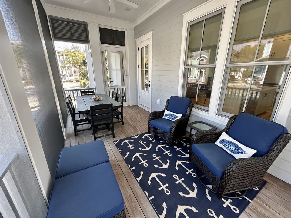 Your screened porch offers a perfect spot to unwind with comfortable seating, dining space, and nautical touches creating a coastal retreat.