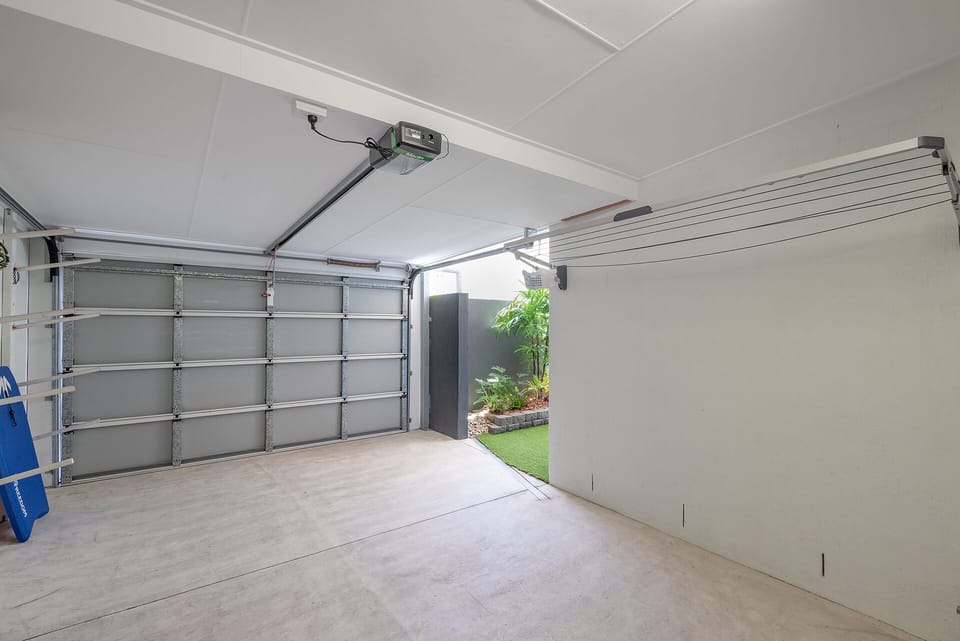 Private garage with direct indoor access, accommodates small car only.