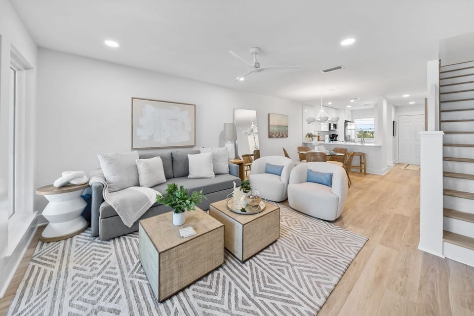 Sink into plush seating with coastal blue accents while natural light floods your stylish open-plan space.