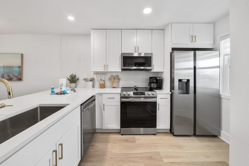 Your sleek modern kitchen awaits with stainless steel appliances and bright white countertops, perfect for whipping up memorable meals during your stay.