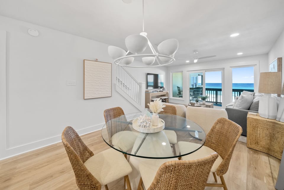 Your bright dining area flows into the living space, where stunning ocean views through floor-to-ceiling windows create the perfect backdrop for meals.