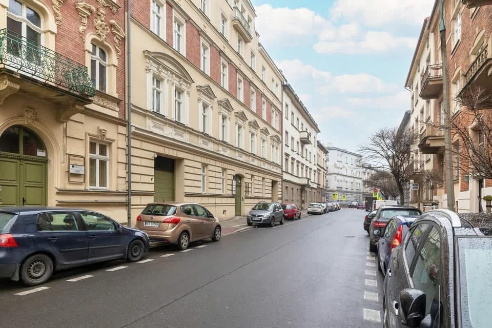 A quiet city street lined with historic buildings, parked cars, and elegant facades, showcasing classic European architecture.






