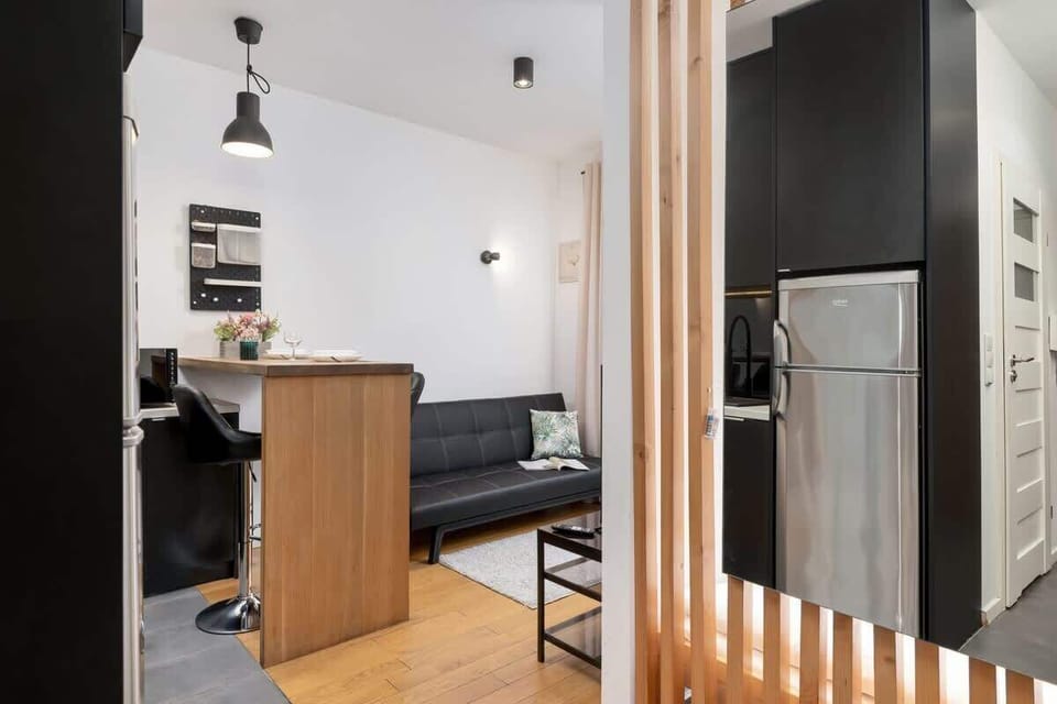 A wider perspective of the open-concept living and kitchen area, featuring a mix of wood, black, and neutral tones.

